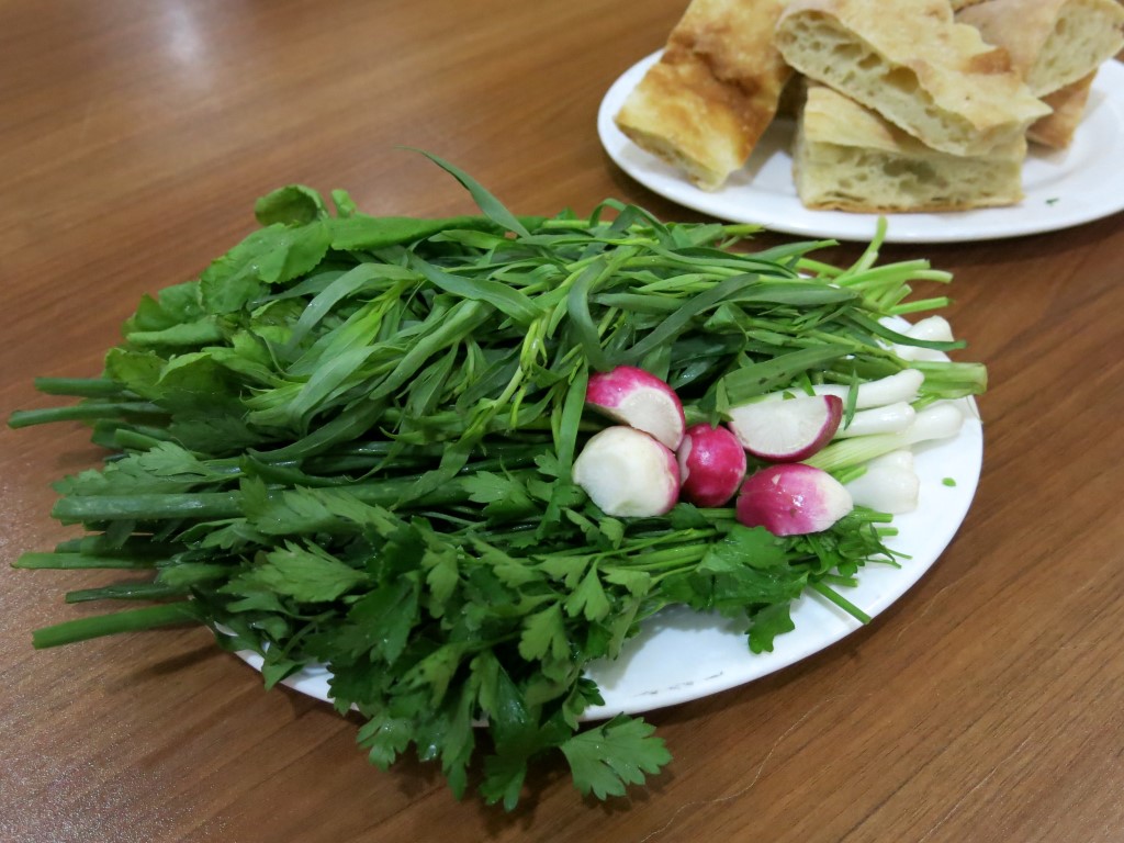 Teller mit Kräutern und Radieschen