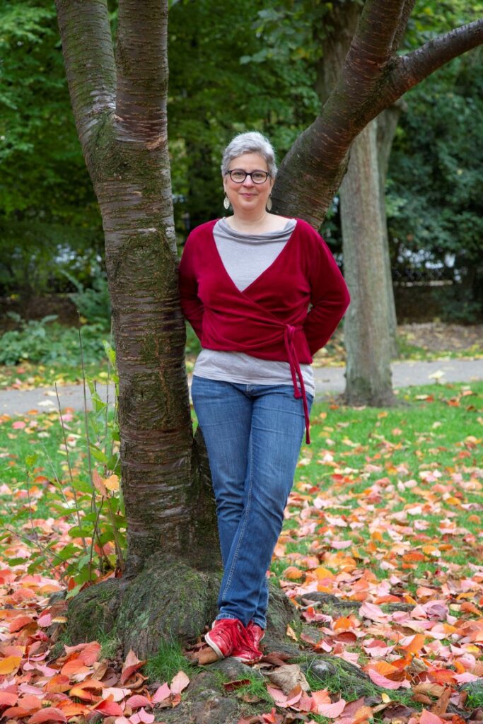 Sabine Schlimm, an einen Baum gelehnt